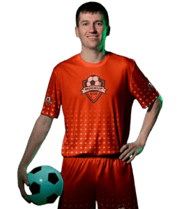 Jugador de fútbol masculino en uniforme naranja sosteniendo un balón de fútbol, posando con una sonrisa.